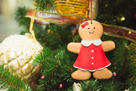 Christmas tree with gingerbread as decor and lights with copy space on blurred bokeh background in mall. Close up. Details.の写真素材