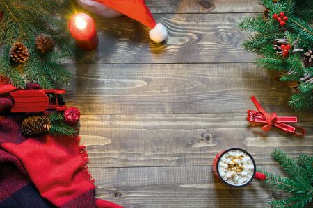 Christmas composition of wreath,checkered pleid, cup of coffee on wooden board. Flat lay. Top view. Copy space.の写真素材