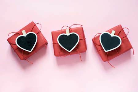 Valentine day composition: three red gift boxes with clothespin as heart with space for text on...