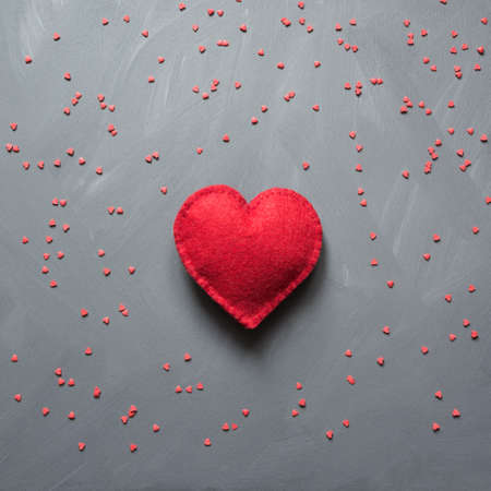 Beautiful valentines day background with red hearts on grey neutral background. Square image. Top...
