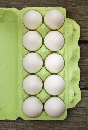 Green carton of organic eggs on wooden background with instant photograph. Top view.の写真素材
