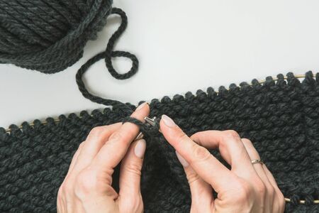 Close-up of hands knitting snud. Process of knitting. Top view. Copy space.