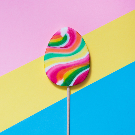 Lollipops candy as egg on colorful background. Funny easter concept. Top view. Square image.