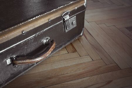 Vintage closed suitcase on the parquet. Selective focus.