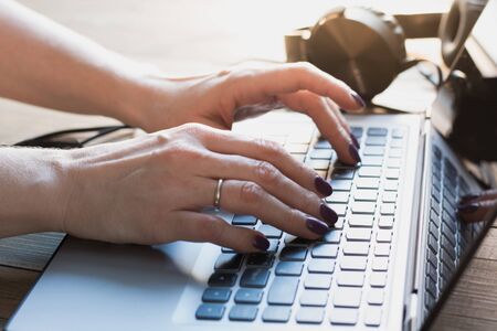 Close up of woman hands working with a laptop in office.の写真素材