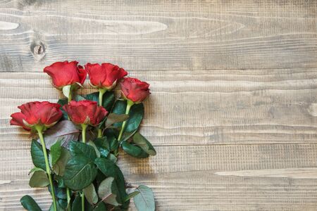 Bunch of red roses on wooden board. Top view. Copy space.の写真素材