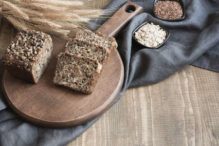 A loaf of fresh rustic whole rye bread on wooden board. Healphy food background. Close up. Copy space. Fitness wholegrain bread.の写真素材