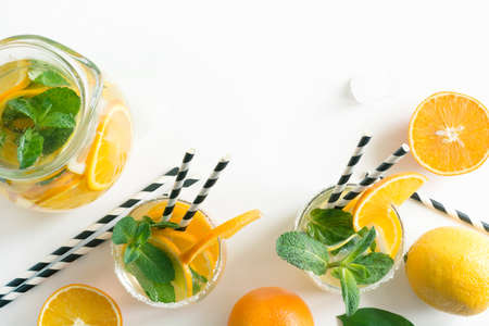 Fresh summer lemonade with citrus, orange and mint on yellow background. Top view. Copy space.の写真素材