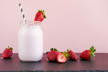 Strawberry milkshake and with berry in mason jar on pink. Close up. Summer food.の写真素材