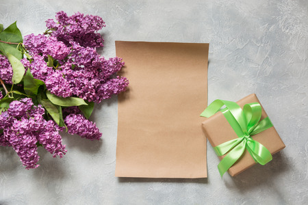 Bouquet purple lilac flowers with gift and space for text on kraft paper. View from above.の写真素材