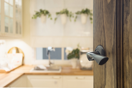 Opened wooden door to modern kitchen interior for background.の写真素材