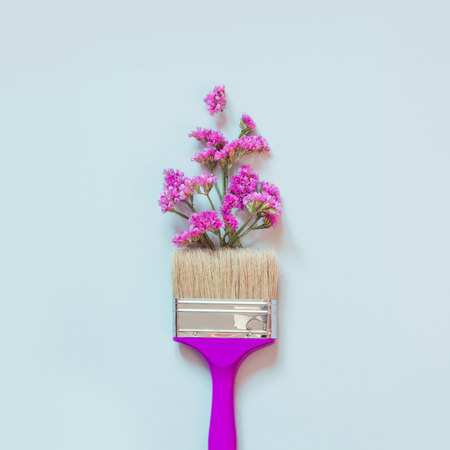 Violet and pink autumn flowers and paint brush on blue background. Fashion minimal art. Fall concept.の写真素材