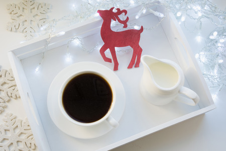 Cup of black coffee on winter white table with garland. Xmas holiday time. Top view.の写真素材