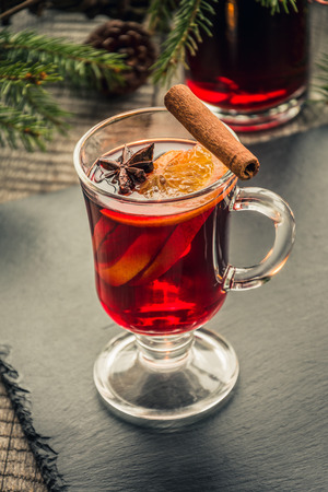 Christmas mulled wine with cinnamon and orange on wooden rustic board. Traditional hot drink at Christmas time.の写真素材