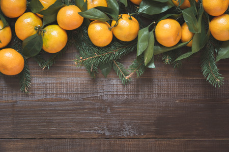 Fresh mandarins with leaves on wooden board. Christmas composition with copy space.の写真素材