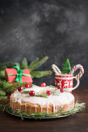 Traditional homemade Christmas cake decorated cranberry berry and rosemary on plate.の写真素材