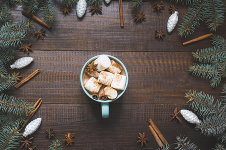 Christmas mug of hot coffee with marshmallow, candy cane on wooden board. New Year. Holiday card. Rustic style. Top view and copy space.の写真素材