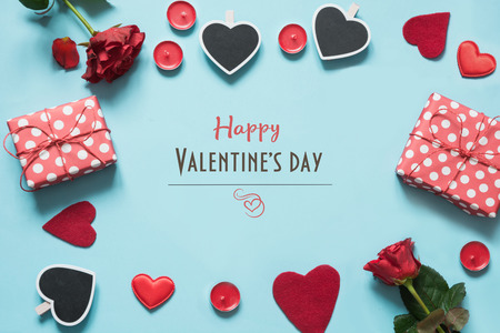 Valentines day card. Composition with gifts, red hearts on blue surface. Top view. Copy space.