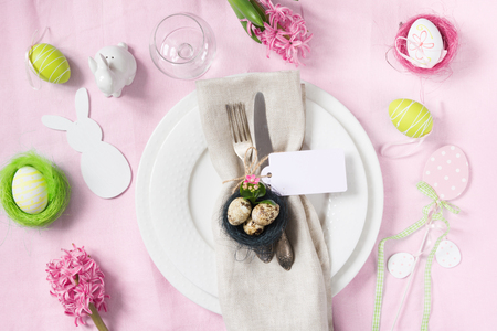 Easter table setting with pink hyacinth flowers on pink linen tablecloth. Easter romantic dinner. Top view.の写真素材