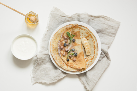 Tasty traditional russian pancakes, sour cream, honey on plate. Top view. Pancake week. Shrovetideの写真素材