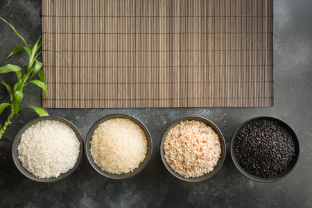 Different varieties of rice in bowls. Top view. Black background. Space for text. View from above.