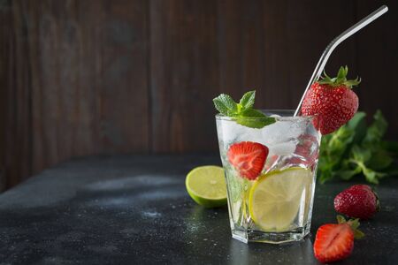 Detox lemonade or mojito with lime, lemon, strawberry in glass. Summer healthy freshness drink.の写真素材