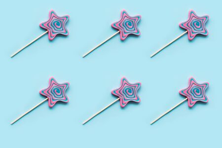 Lollipops swirl candy shaped as star on pastel blue background. Top view. Isometric. Horizontal orientation.の写真素材