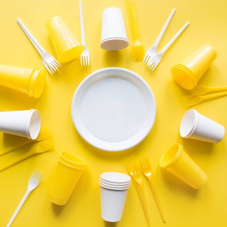 Disposable picnic utensils for recycling on yellow. Environment eco friendly discarded plastic...
