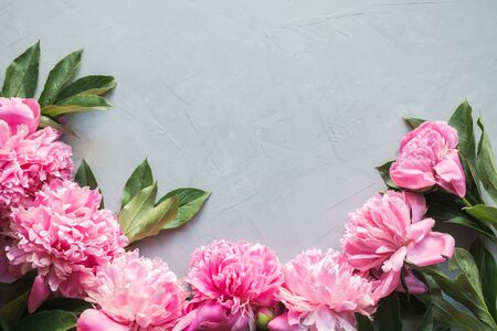 Beautiful pink peony flowers as frame on grey concrete. Copy space for text. Top view. Flat lay.の写真素材