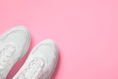 Pair of white female trendy sneakers on pink. Flat lay, top view minimal pink background. Space for text.の写真素材