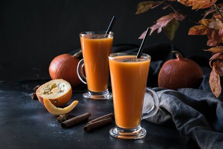 Fresh pumpkin spice smoothie or juice on dark. Autumn, fall or winter hot drink on dark black background. Cozy healthy beverage. Close up. Thanksgiving drink.の写真素材