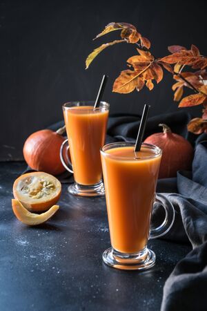 Fresh pumpkin spice smoothie or juice on dark. Autumn, fall or winter hot drink on dark black background. Cozy healthy beverage. Close up. Thanksgiving drink.の写真素材