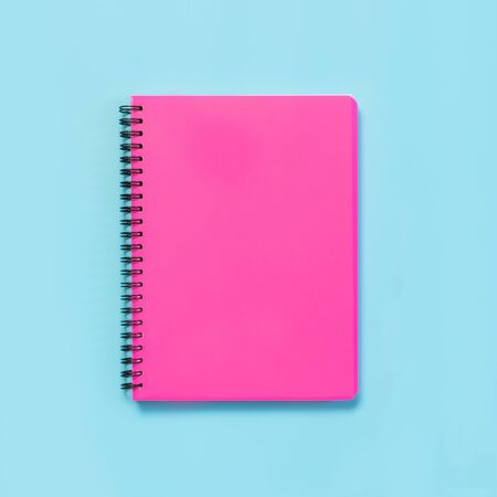 Pink girlish school supplies, notebooks on blue background. Top view, flat lay. Copy space.の写真素材