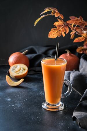 Fresh pumpkin spice smoothie or juice on dark. Autumn, fall or winter hot drink on dark black background. Cozy healthy beverage. Close up. Thanksgiving drink.の写真素材