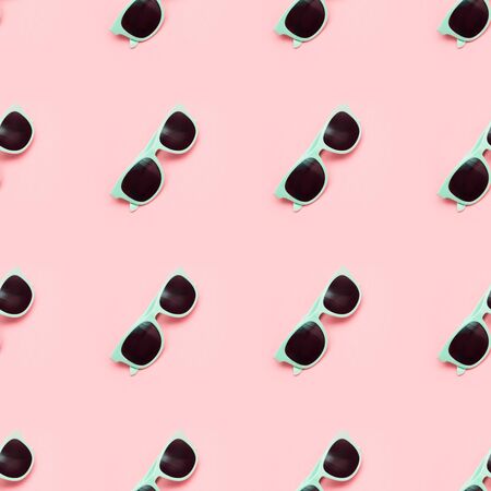 Green pastel sunglasses isolated on punchy pink, top view. Summer concept. Seamless pattern.の写真素材