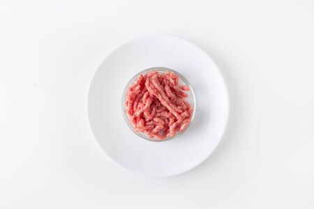 Minced meat in glass Petri dish for laboratory studies on white table. Chemical experiment. Top view.の写真素材