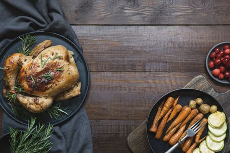 Traditional roasted turkey garnish vegetables and rosemary on dark wooden table. Top view....