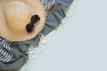 Straw beach sunhat and sun glasses on yellow with space for text. Female outfit. Summer vacancy concept.の写真素材
