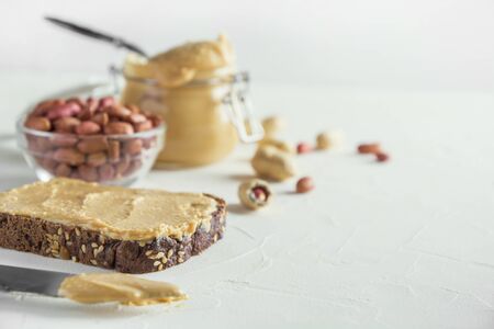 Peanut paste on brown whole grain bread. Healthy nutrition concept. Close up. Space for text.の写真素材