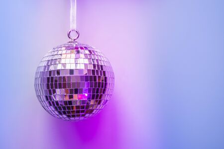 Christmas disco and mirror ball on neon pink and blue. Creative Xmas party background with copy space.の写真素材