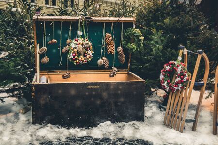 MOSCOW, RUSSIA 28 DEC 2018. Large chest with wreath and decorative vintage sleigh for gifts surrounded by Christmas trees. Christmas celebration and fairy on Red Square. New year.のeditorial素材