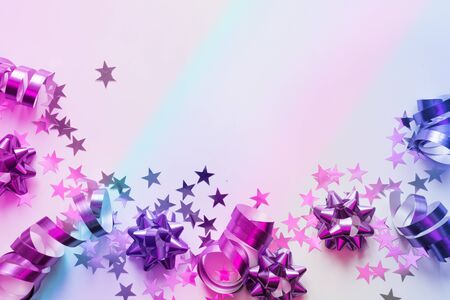 Christmas frame of silver and pink pastel decoration, streamers, tinsel, star, neon gradient on white. Xmas. Flat lay style. Top view with copy space.