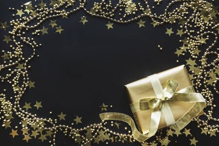 Border of luxury golden gift box on black background. Christmas present. Flat lay. Top view. Xmas.