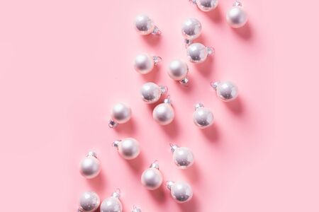 Christmas background with silver balls on pink. Top view with copy space. Xmas holiday pattern. New Year. Flat lay.の写真素材