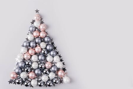 Christmas tree made of stars, confetti, silver pastel balls on grey background. Xmas composition. Flat lay, top view, copy space. Holiday Greeting card. Happy New Year.の写真素材