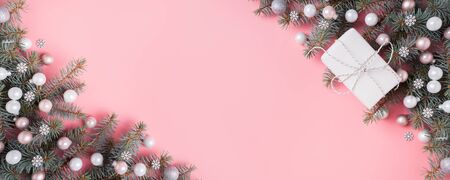 Christmas silver pink glass ball and fir branches on pink background. Xmas banner with space for...