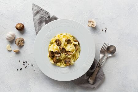 Spaghetti reginelle pasta with mushrooms on white. Tasty healthy mediterranean and italian dinner. View from above.の写真素材