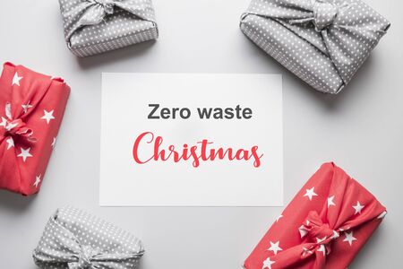 Zero waste Christmas. Sustainable gifts wrapped in red and grey textile. Xmas eco holiday. Japanese Furoshiki style. View from above. Flat lay.の写真素材