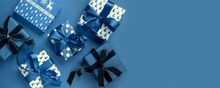 Christmas banner of holiday gifts on blue background. Boxing day. Greeting card. Winter. Happy New Year. View from above, flat lay. Template, mockup.の写真素材