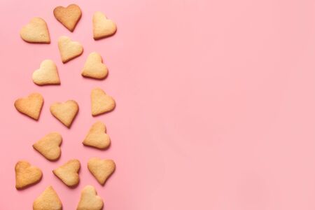 Border of homemade heart shaped cookies on pink background. Top view. Valentines day greeting card. Flat lay.の写真素材
